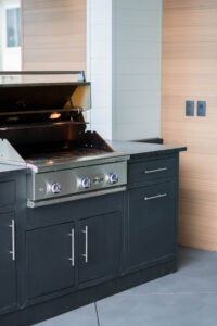 Outdoor grill with black cabinetry and stainless steel features.